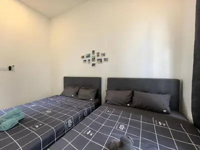 a bedroom with two beds and a teddy bear on the floor at Padang Serai Wangi Roomstay 91 in Padang Serai