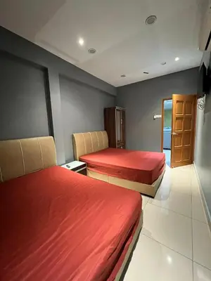 a hotel room with two beds with red sheets at Alma Sweet Home in Bukit Mertajam