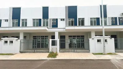 a building with a gate in front of a parking lot at 2 Bedroom Townhouse Homestay In Bandar Dato Onn in Gua Sai