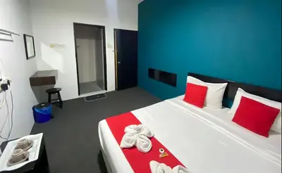 a bedroom with a large bed with red and blue walls at Captain Hotel Cafe & Bistro in Sitiawan