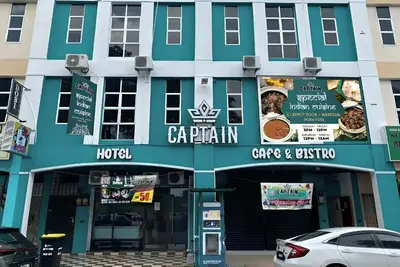a building with a sign for a restaurant at Captain Hotel Cafe & Bistro in Sitiawan