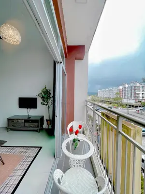 a balcony with two white chairs and a television at Lily Studio in Brinchang