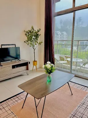 a living room with a vase of flowers on a coffee table at Lily Studio in Brinchang