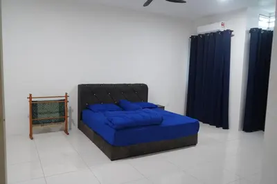 a bedroom with a blue bed with blue pillows at Homestay Behrang Sentral in Kampung Behrang