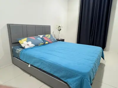a bedroom with a bed with a blue comforter at Homestay Behrang Sentral in Kampung Behrang