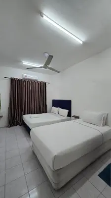 a bedroom with two beds and a ceiling at Anjung Vacation Home No 70 in Gua Sai