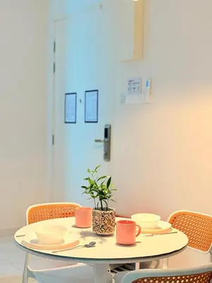 a table with plates and cups and a plant on it at The Sun Executive Suite - Dolphin's Home in Bayan Lepas