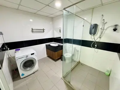a bathroom with a shower and a washing machine at Mansion One studio in George Town