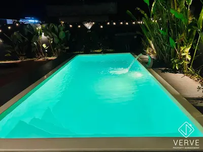 a swimming pool in a garden at night at Ipoh Lazy Private Club House 4B3B by Verve 14 pax in Tambun