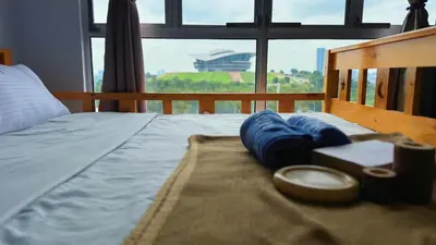 a bed with blue pillows on it with a window at PPAM Seruling Presint 5, Putrajaya 4BR with PICC View and Garden View Homestay