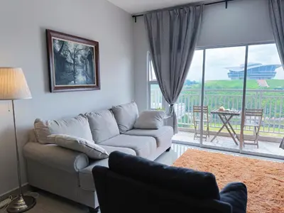 a living room with a couch and a table and a window at PPAM Seruling Presint 5, Putrajaya 4BR with PICC View and Garden View Homestay