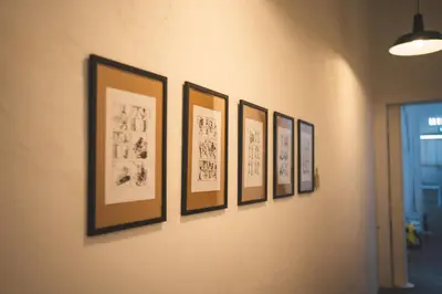 a row of framed drawings on a wall at Carnarvon 73 in George Town