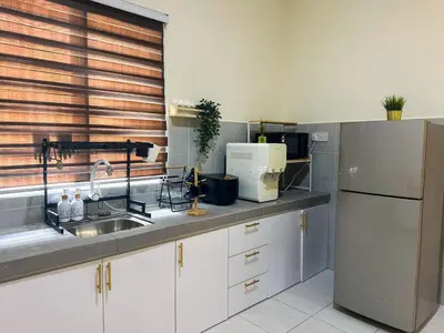 a kitchen with a sink and a refrigerator at Hana Homestay Seri Iskandar in Seri Iskandar