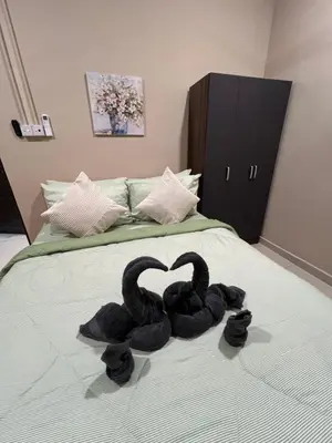 two black swans are sitting on a bed at Rumah No 5 in Taiping