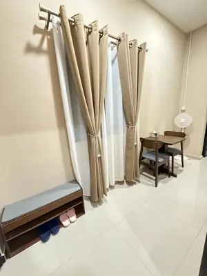 a room with curtains and a table and a chair at Rumah No 5 in Taiping