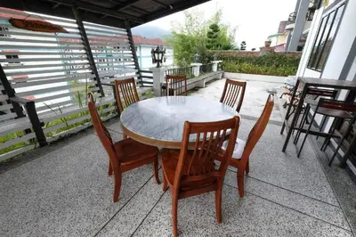 a wooden table and chairs on a patio at Holiday Bungalow Guesthouse in Tanah Rata