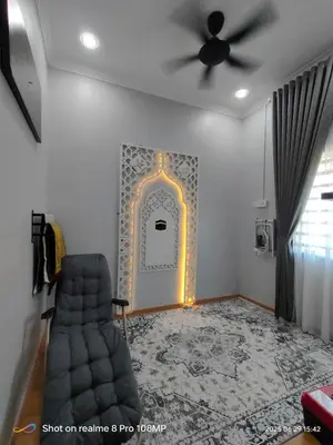 a living room with a chair and a wall with a door at Homestay Saujana Hill in Gua Musang