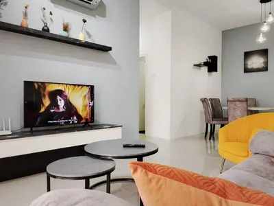 a living room with a couch and a tv at Ipoh Cove Hillside Mini Waterpark Family Suite in Ipoh