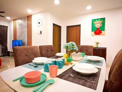 a dining room with a table with plates and bowls at Ipoh Manhattan Free Waterpark 3BR 8Pax Family Suite MHA306 by City Home Empire in Ipoh