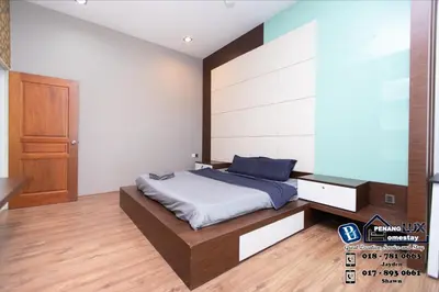 a bedroom with a large bed with a wooden headboard at Jambul Residence 15 in Gua Sai