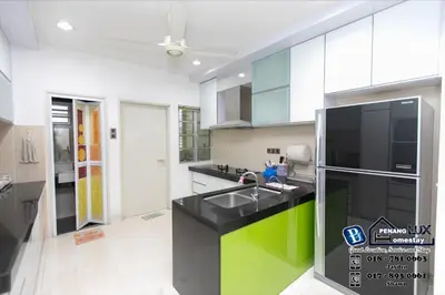 a kitchen with a sink and a refrigerator at Jambul Residence 15 in Gua Sai