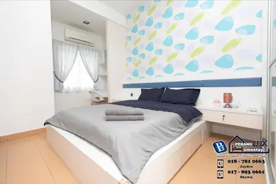 a bedroom with a bed with a blue and white wall at Jambul Residence 15 in Gua Sai