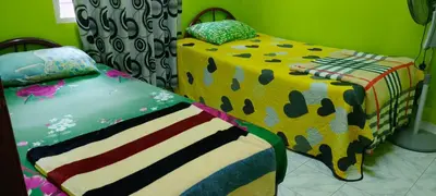 a bedroom with two twin beds with colorful covers at Homestay bonda tanjung malim in Kampong Keteyong