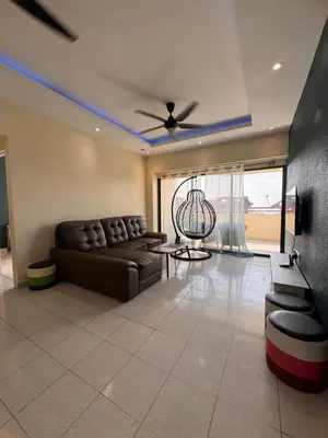 a living room with a couch and a ceiling fan at Sri Sayang sunset 2 bedroom in Batu Ferringhi