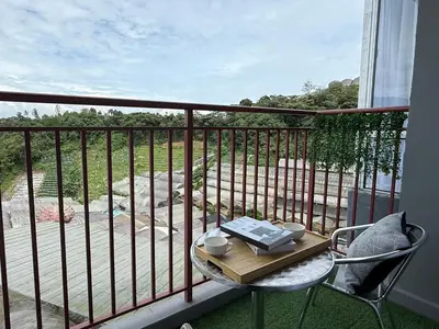a table and chairs on a balcony with a view at Cozy 3BR Emerald Avenue Brinchang, 8pax Netflix in Brinchang