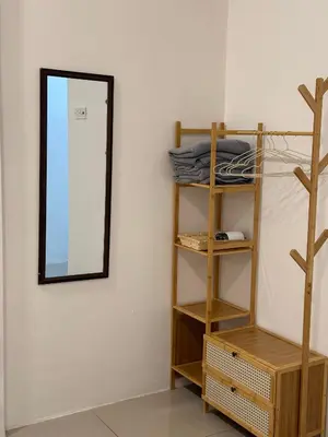 a mirror on a wall next to a shelf at Cozy Inn Homestay in Kampar