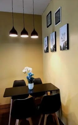 a dining room with a table and chairs and some lights at ZE I Cameron Jaya, Tanah Rata in Tanah Rata