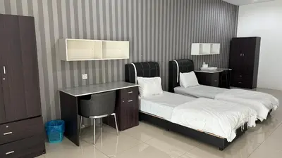 a room with two beds and a desk and a bar at Summer Hotel Kampar Perak in Kampar