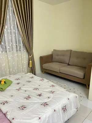 a bedroom with a bed and a couch at Mumtaz Homestay in Kampong Belah Dua