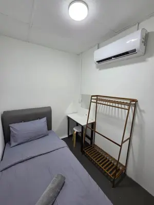 a small bedroom with a bed and a desk at The Ipohstay hostel in Ipoh