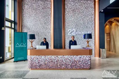 two people standing at a counter in a lobby at 22 Macalisterz by ALV in George Town