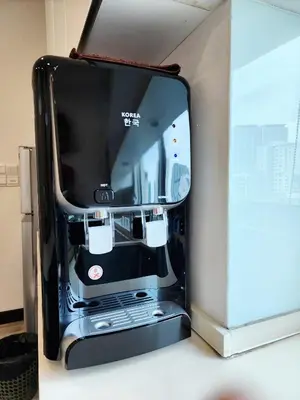 a black appliance sitting next to a white refrigerator at The Tiny Treasure Stay #1BR in George Town