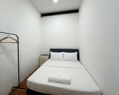 a small room with a white bed in it at Toh Aka Inn in George Town