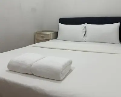 a white bed with a white pillow on it at Toh Aka Inn in George Town