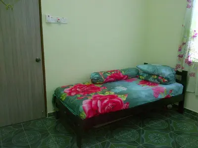 a bed in a room with pink roses on it at Penang Green Homestay in Permatang Pauh