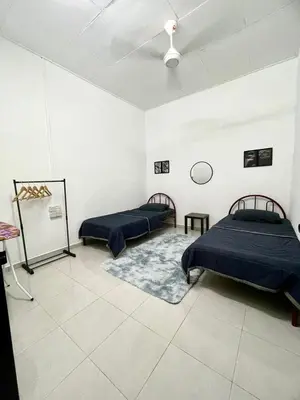 two beds in a room with white walls at Homestay Bonda F in TanjongMalim