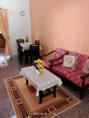 a living room with a couch and a table at Homestay Bait Al-Sakinah in Simpang Ampat