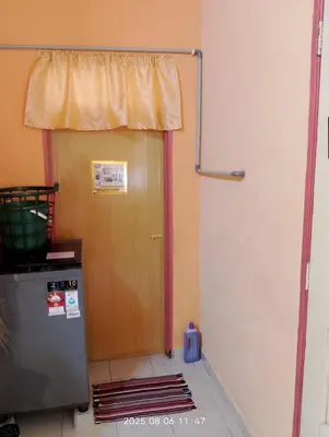 a door leading to a room with a refrigerator at Homestay Bait Al-Sakinah in Simpang Ampat