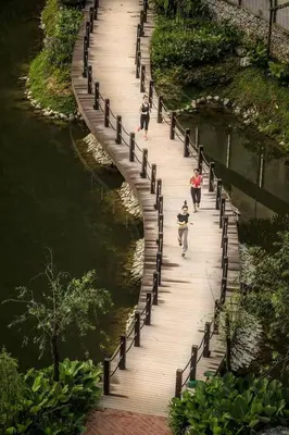 a group of people walking on a wooden bridge over water at The Haven Resort 3 rooms renovated suite in Tambun