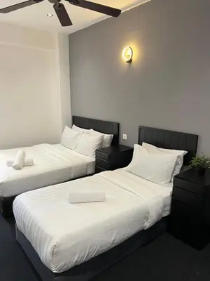 two beds sitting next to each other in a room at Quee Hotel in George Town