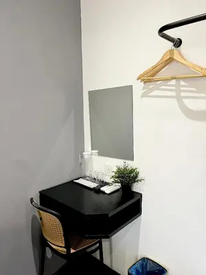 a black desk with a mirror and a chair at Quee Hotel in George Town