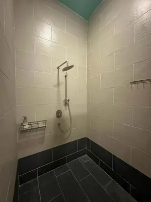 a bathroom with a shower with a tiled wall at Cabin in the Valley in Tambun