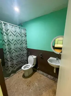 a bathroom with a toilet and a sink at Cabin in the Valley in Tambun