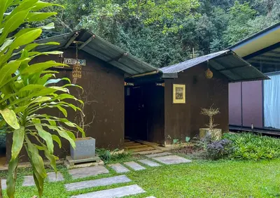 a small building with a black door in a yard at Cabin in the Valley in Tambun
