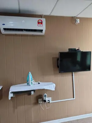 a hospital room with a hospital bed and a tv at QALSHARYNA CHALET inn in Taiping