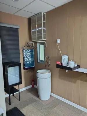 a bathroom with a toilet and a mirror and a tv at QALSHARYNA CHALET inn in Taiping